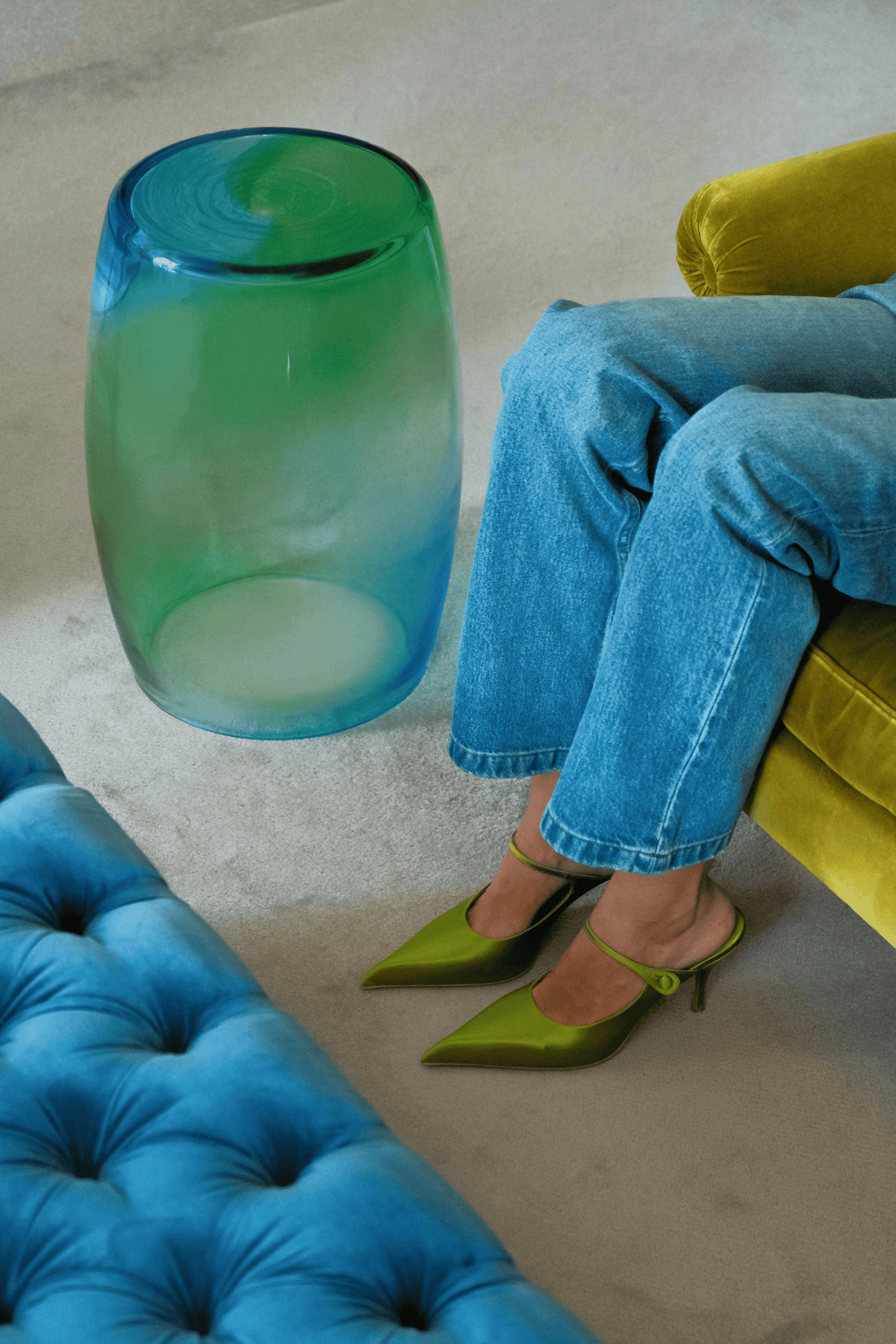 Tavolino Laguna 50 in aquamarine and green beside a velvet sofa, Murano glass table.